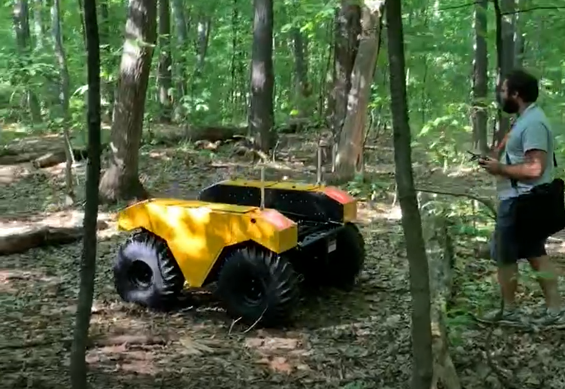 Jean-François Tremblay with a mobile robot in a forest during his Ph.D.