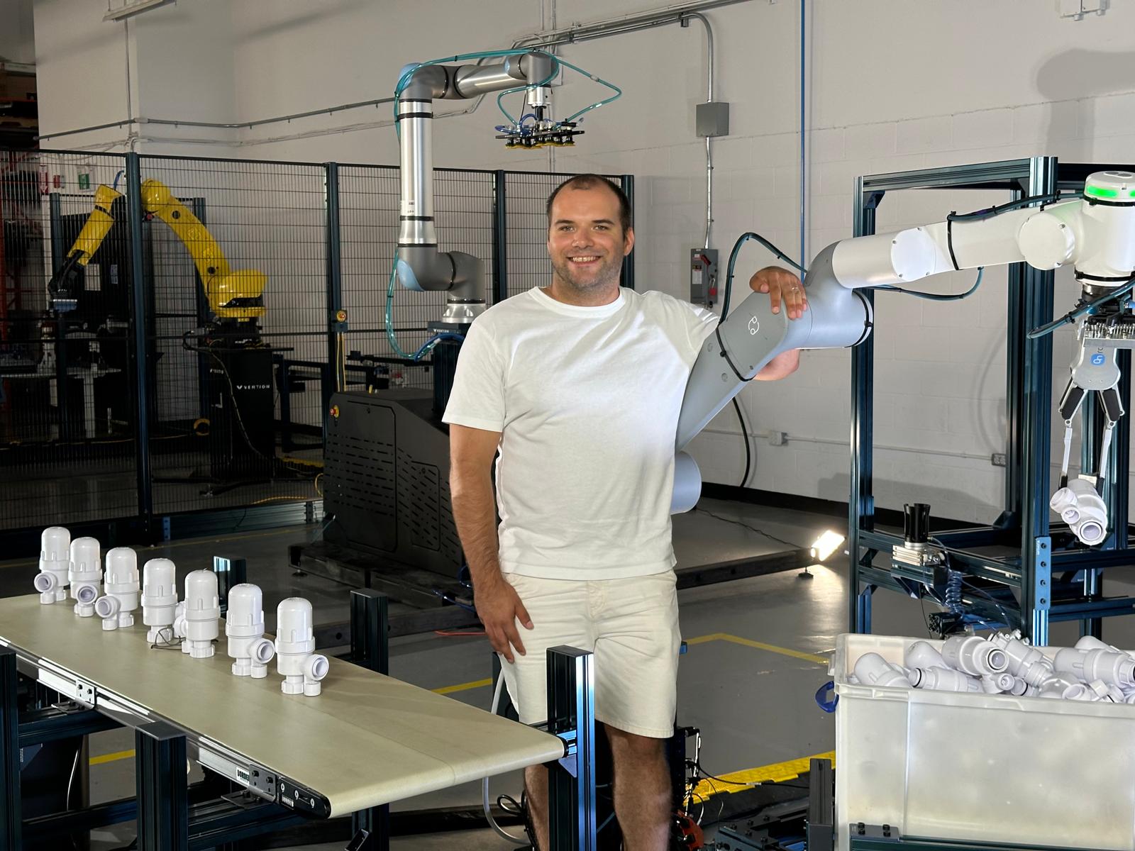 Jean-François Tremblay in the robotics lab at Vention, next to industrial robot arms